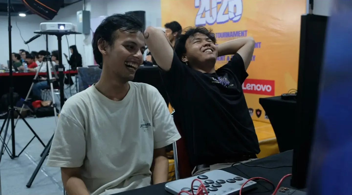 Two players at a tournament station at KO Arena 2026. One is laughing, the other leans back with hands behind the head.
